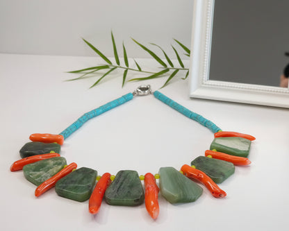 Handmade gemstone necklace with turquoise beads, green stones, orange coral accents on white display